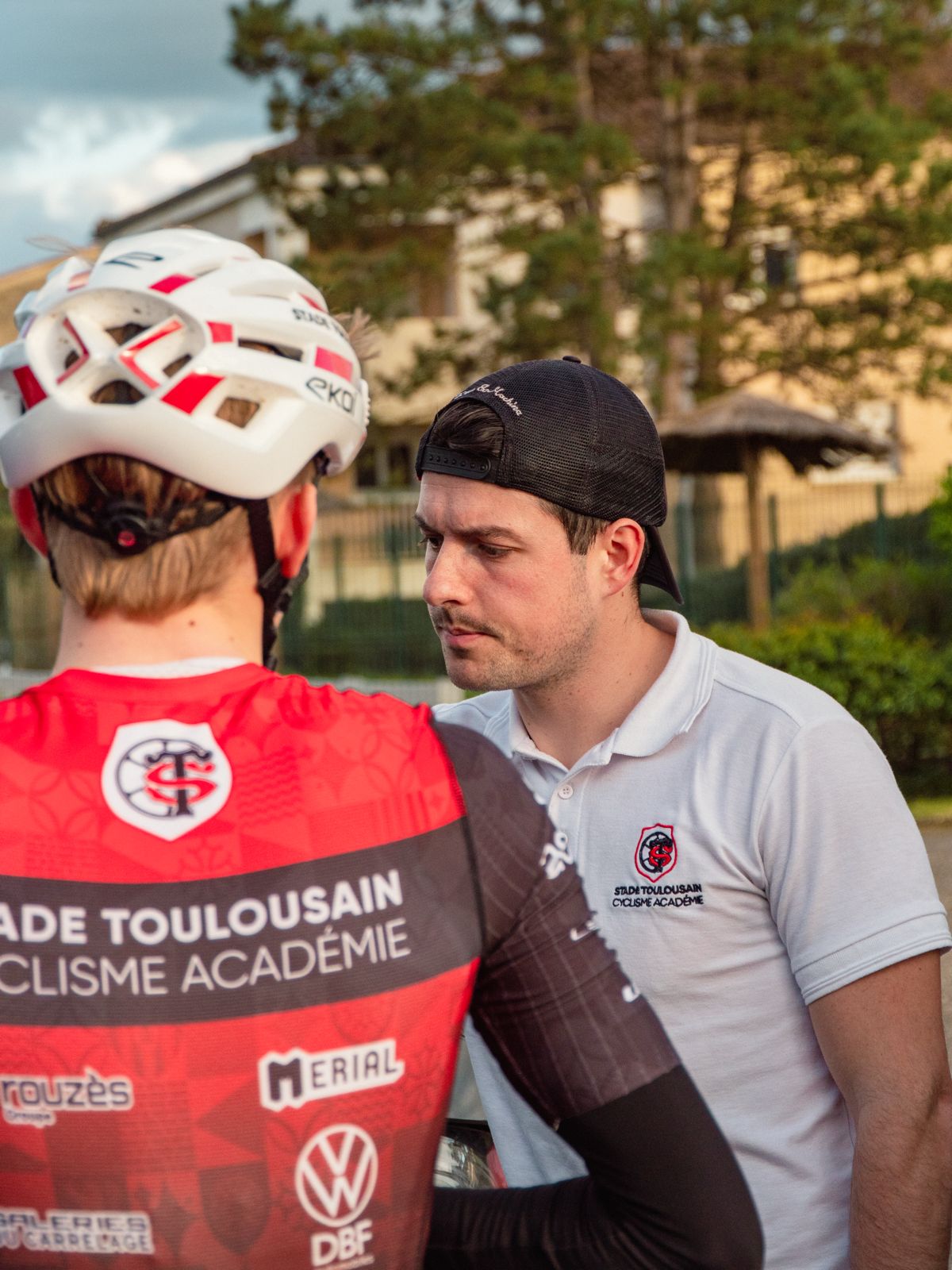 Échange entre un coureur et un membre du staff du Stade Toulousain Cyclisme